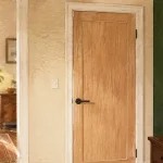 Décoration porte intérieure avec habillage adhésif effet bois clair, porte blanche.