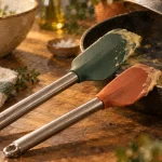 Ustensiles de cuisine en silicone posés contre une poêle antiadhésive